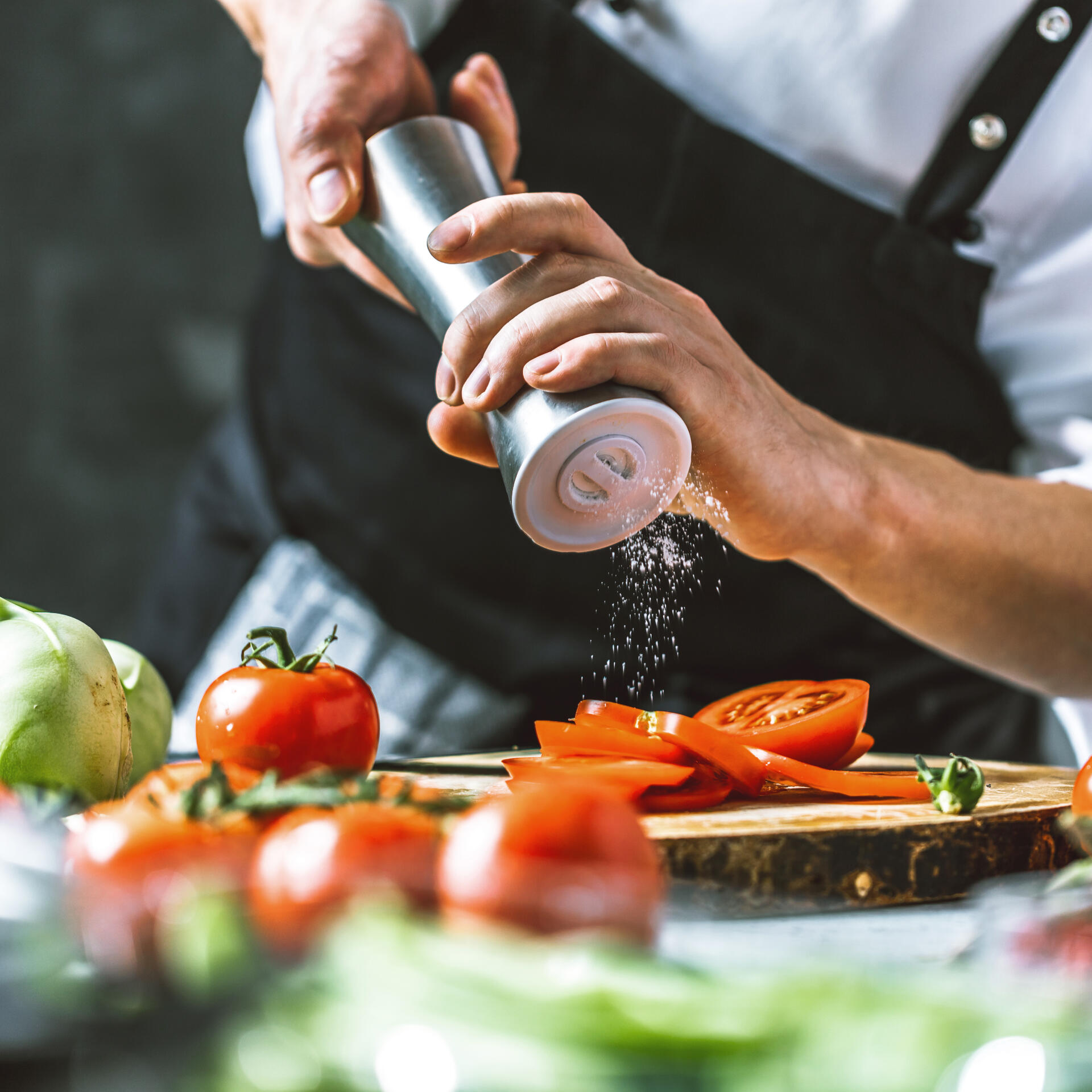 Photo d'un chef qui sale des tomates