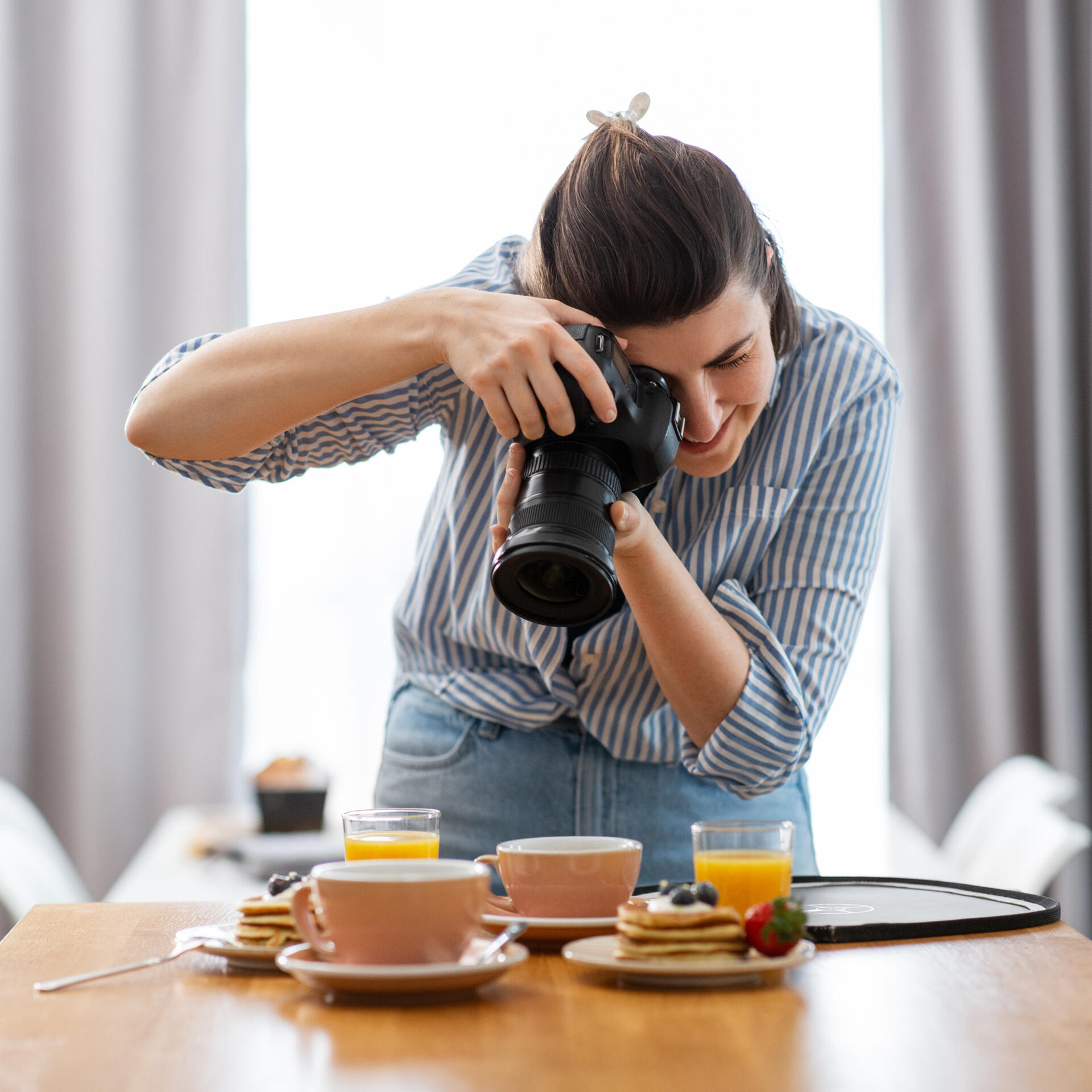 Photo d'une photographe culinaire qui prend une photo d'un petit dejeuner